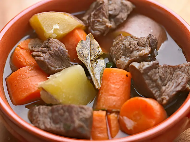 Tender beef stewed with vegetables in a cauldron